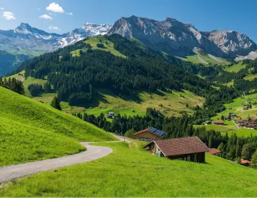 Long trail in a grassy hill with small cottages scattered throughout