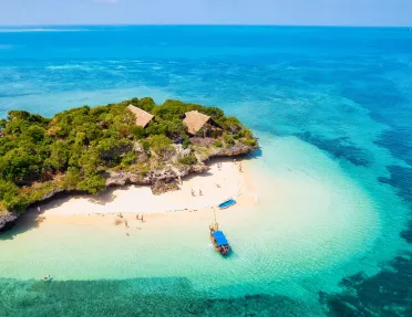 Boat by the ocean coast, with kids playing on the beach