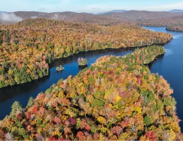 Vibrant fall foliage surrounding a calm lake in Vermont