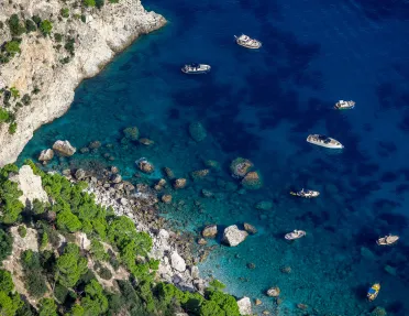 Sky view of boats floating in the ocean by the coast