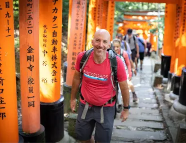 Group of people smiling while walking through large shrine arches