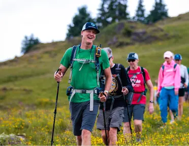 Group of people walking on a valley, using hiking poles