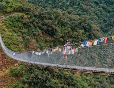 Long, wooden bridge with a woman smiling while walking across