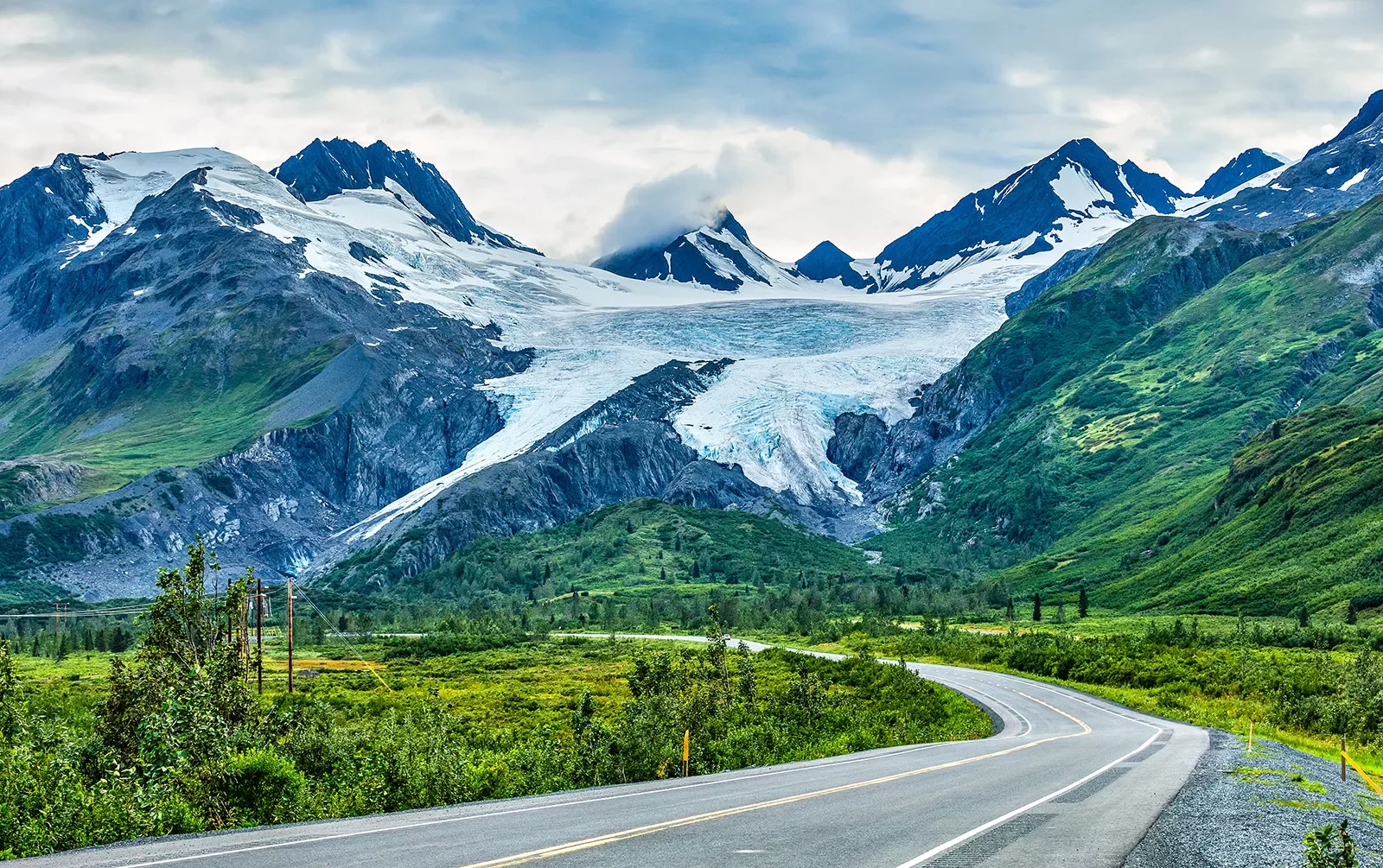 Winding road leading to snow covered mountains in Alaska