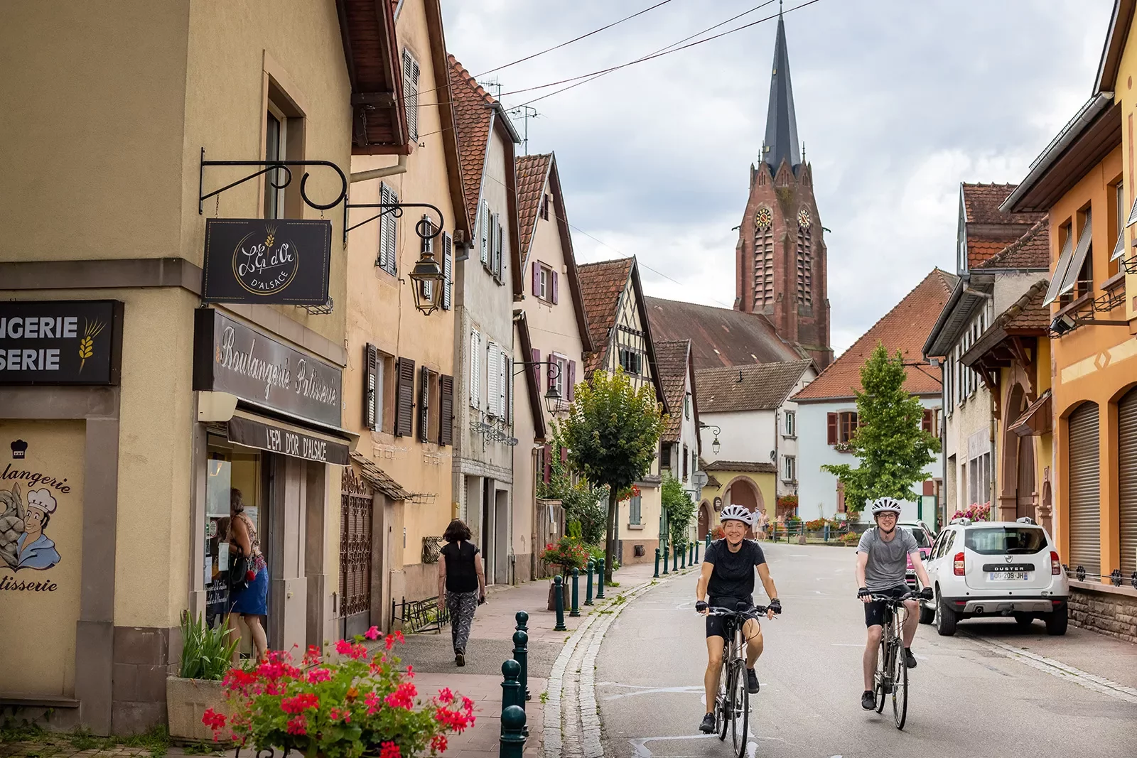 Two Backroads Guests Biking Through Town in Alsace