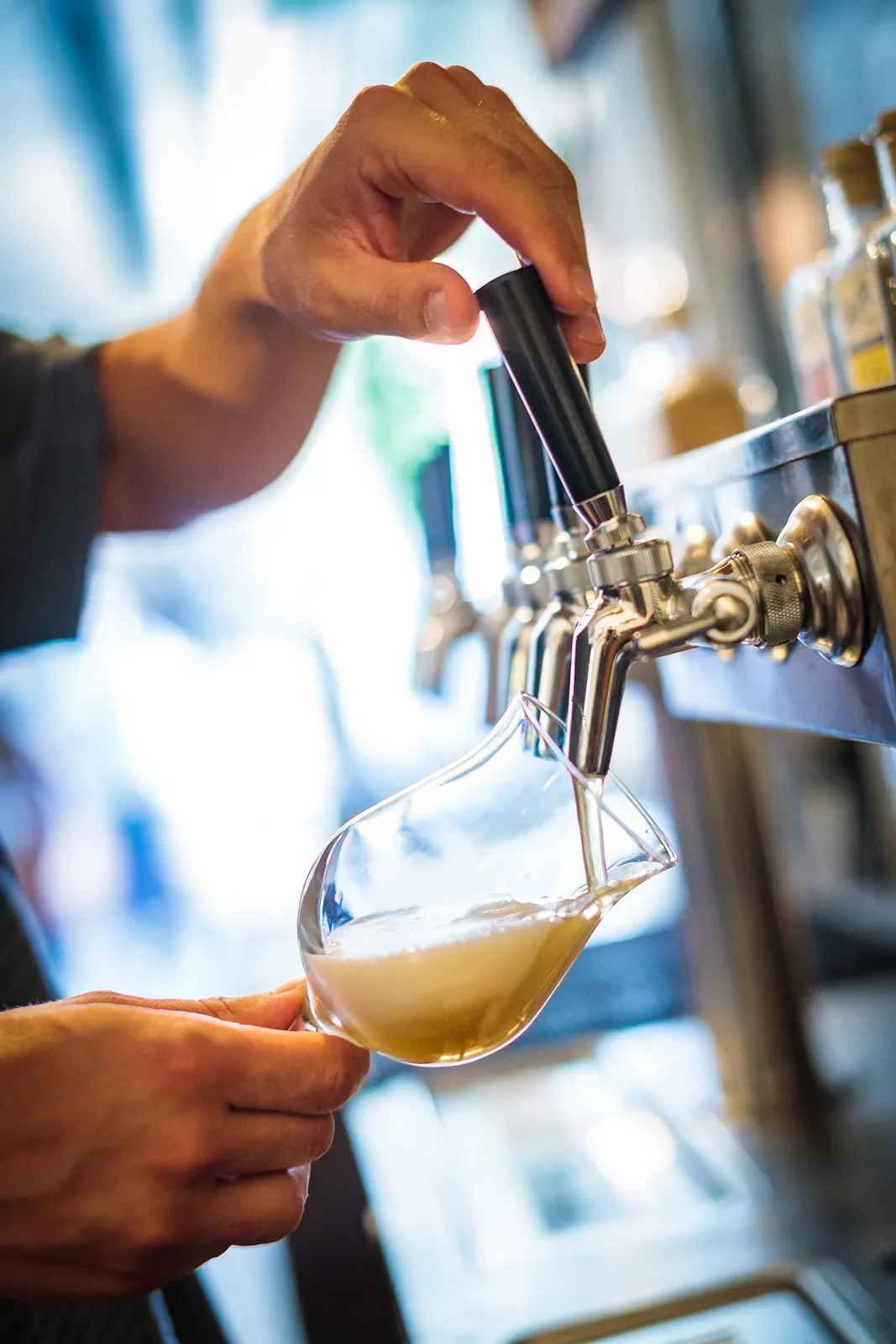 Close-up of a man pouring beer from a tap.