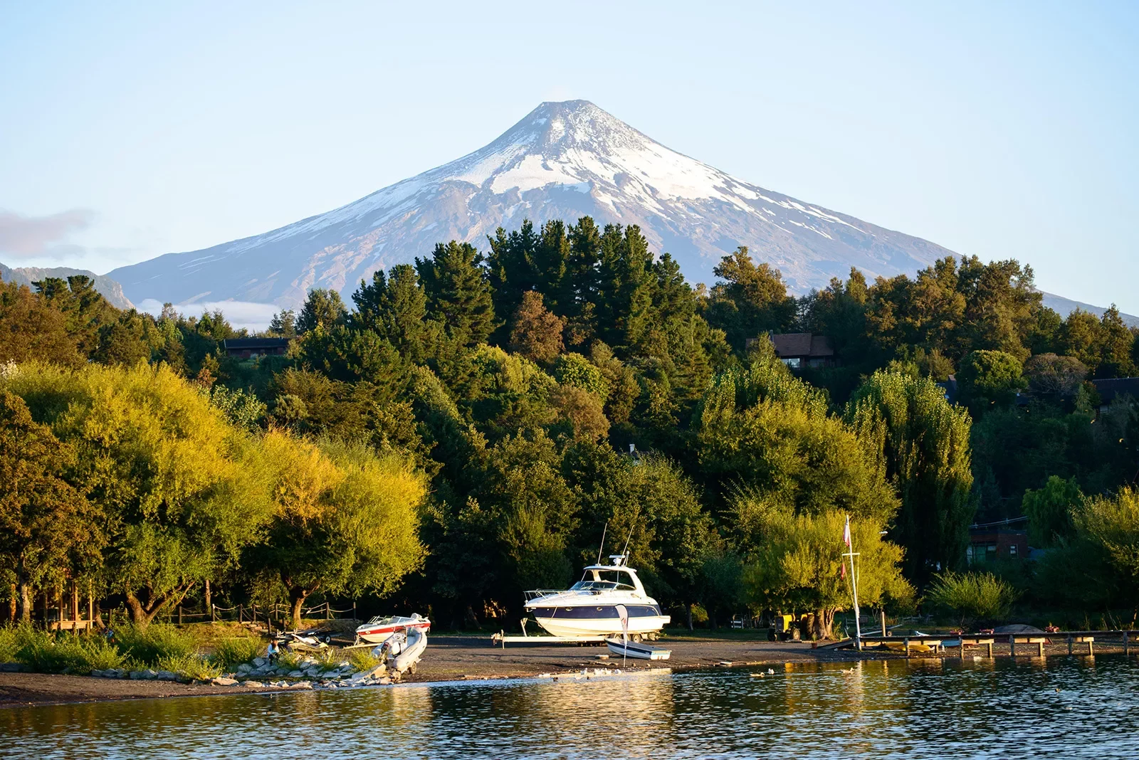 Wide shot of Lago Villarrica, small lake and boat in foreground.