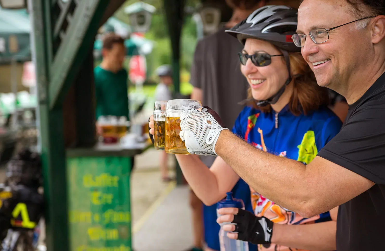Two bikers saying cheers with mugs of beer.