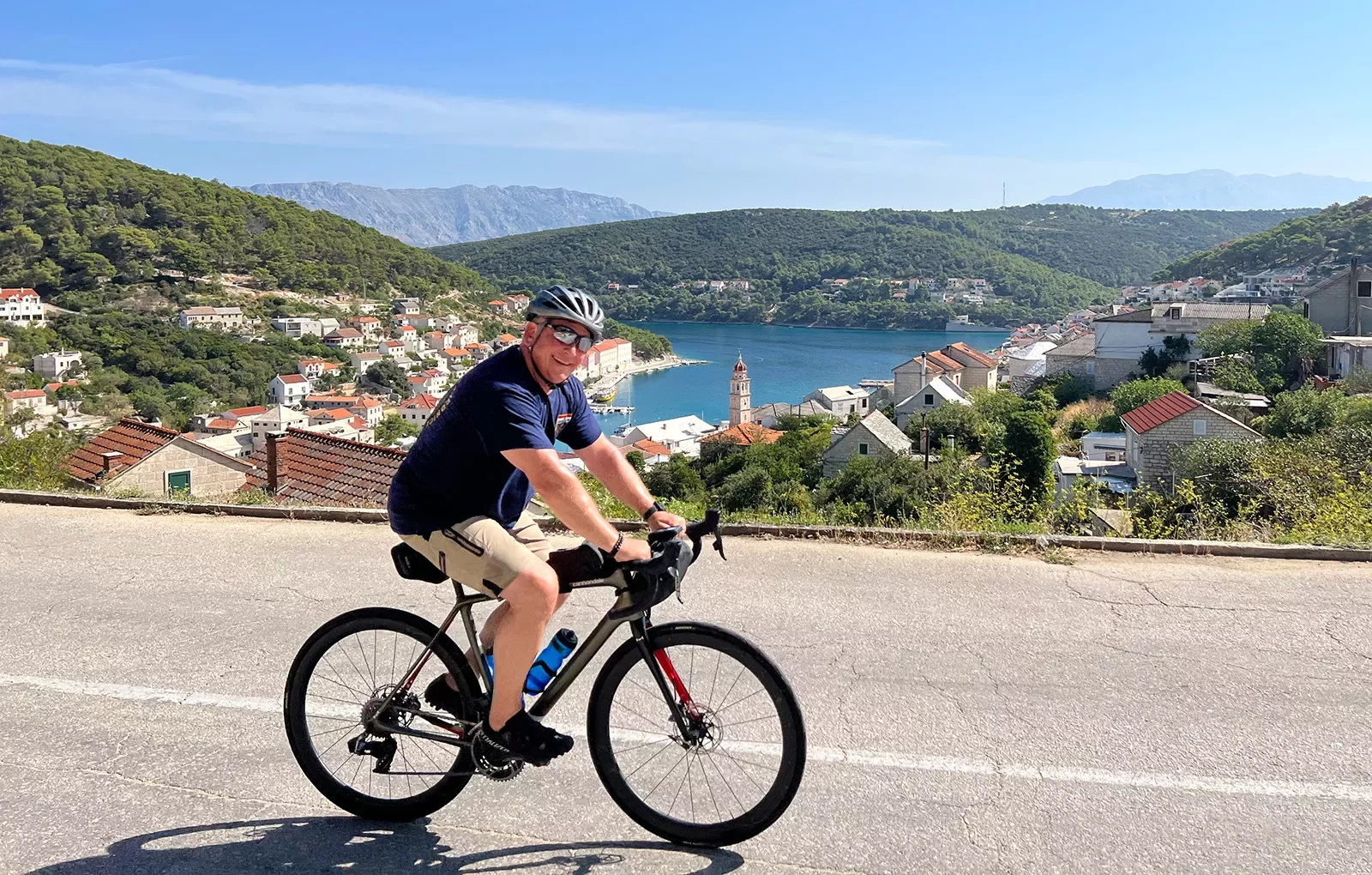 Guest cycling past Croatian riverside town.