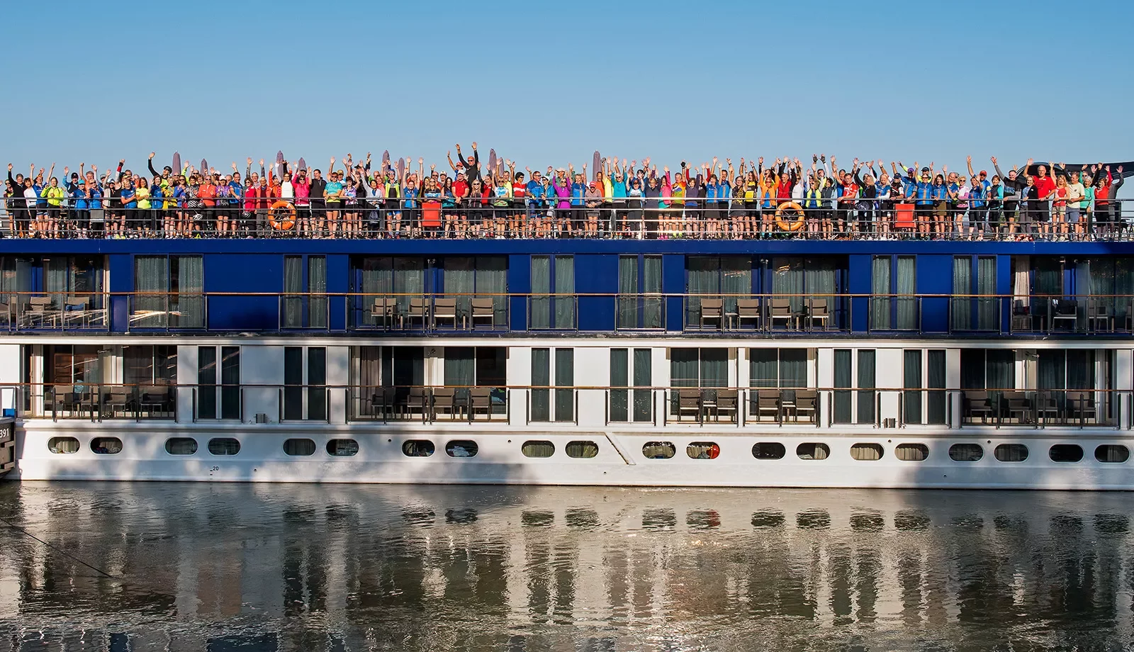 Cruise guests gathered on top deck, celebrating.