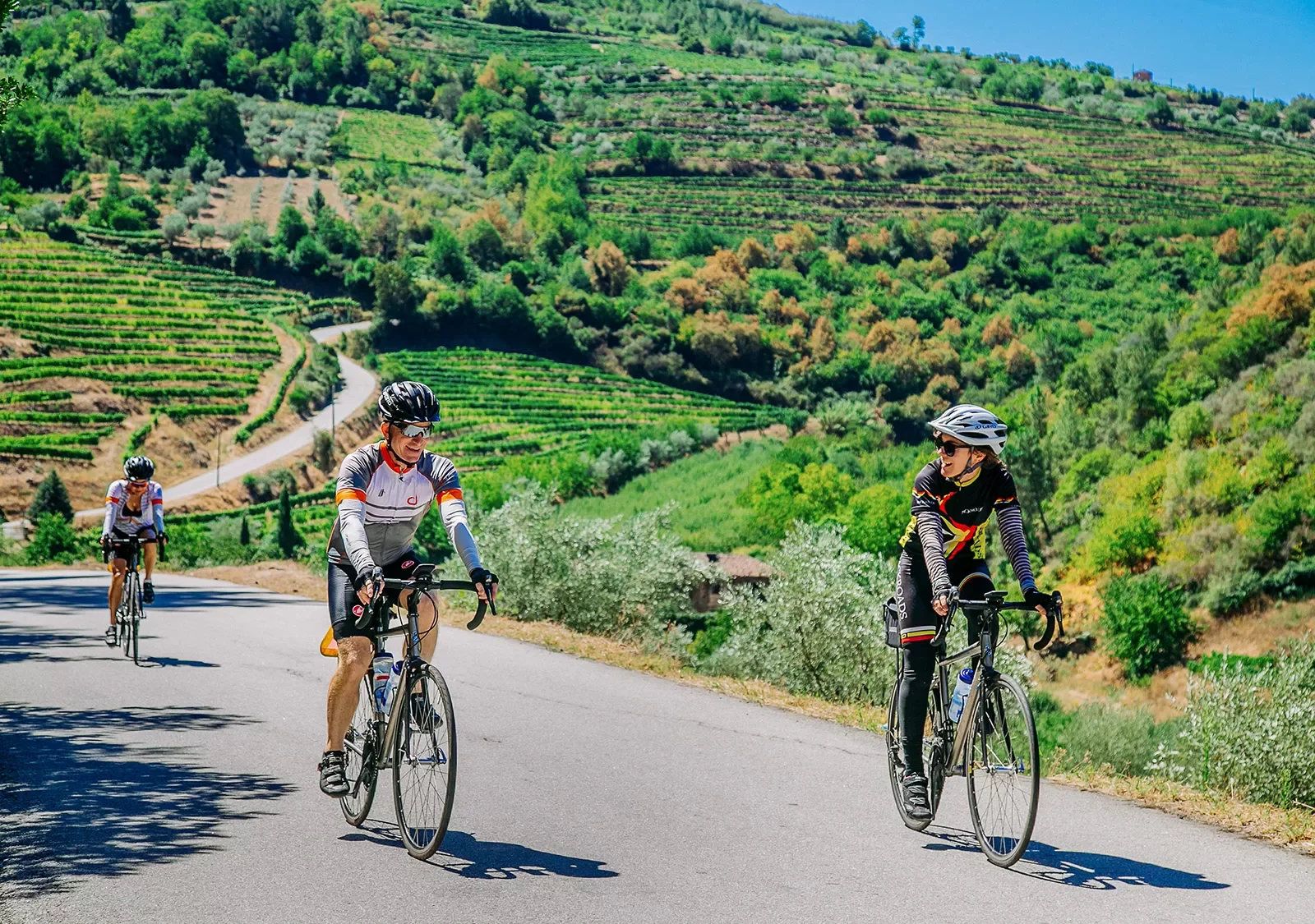 Three bikers riding on a road along the Douro River.