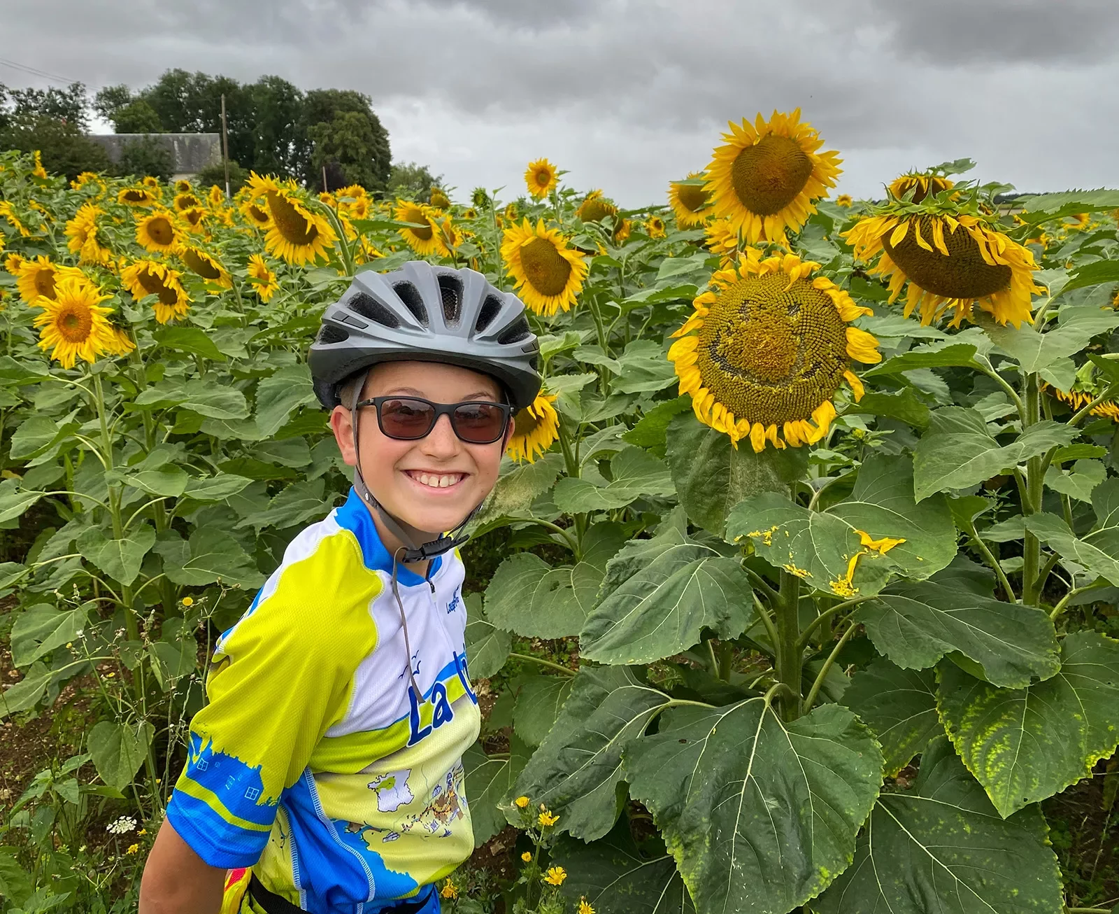 Guest posing in front of large sunflower field.