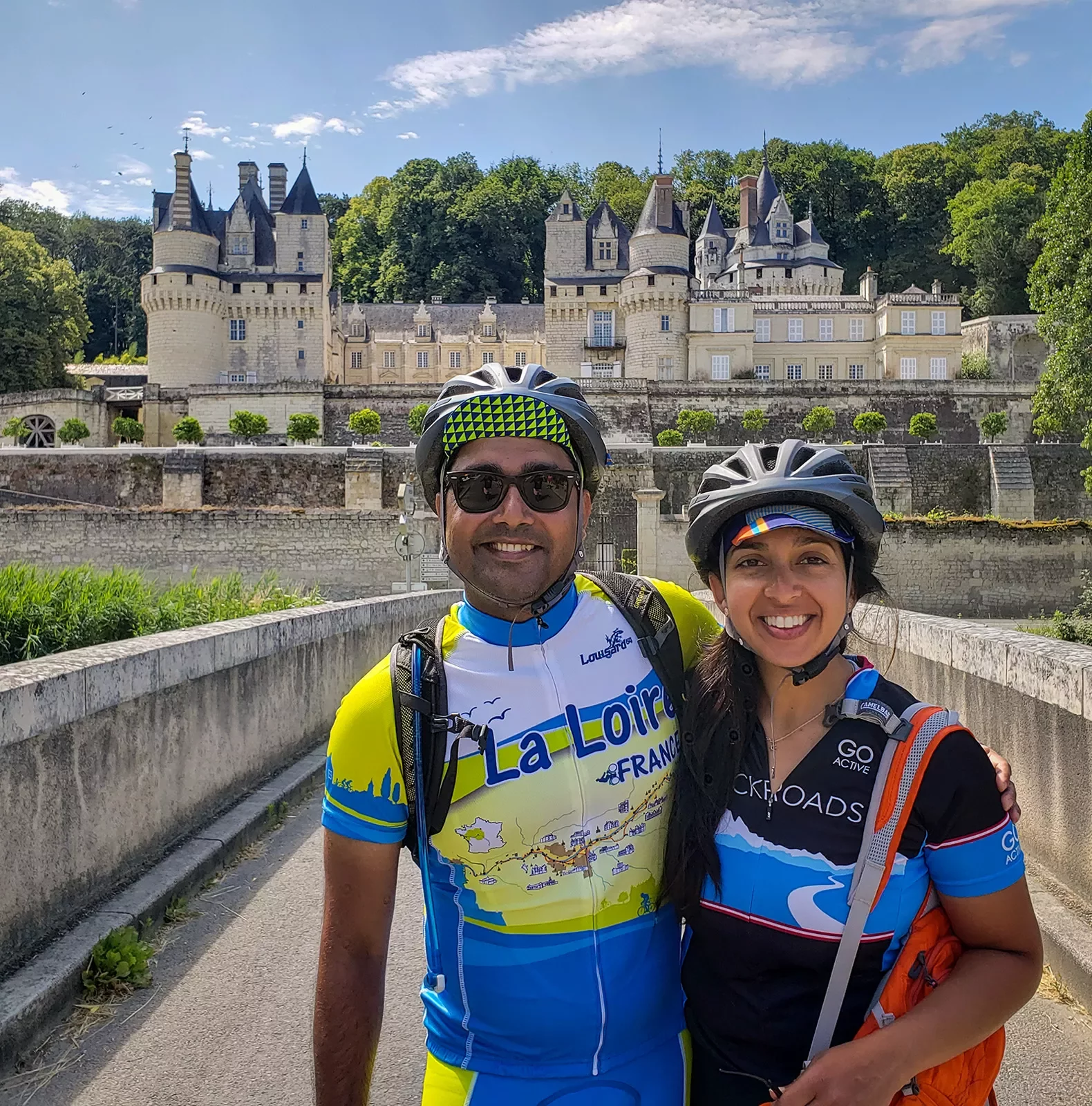 Two guests in bike gear posing in front of Château d'Ussé.