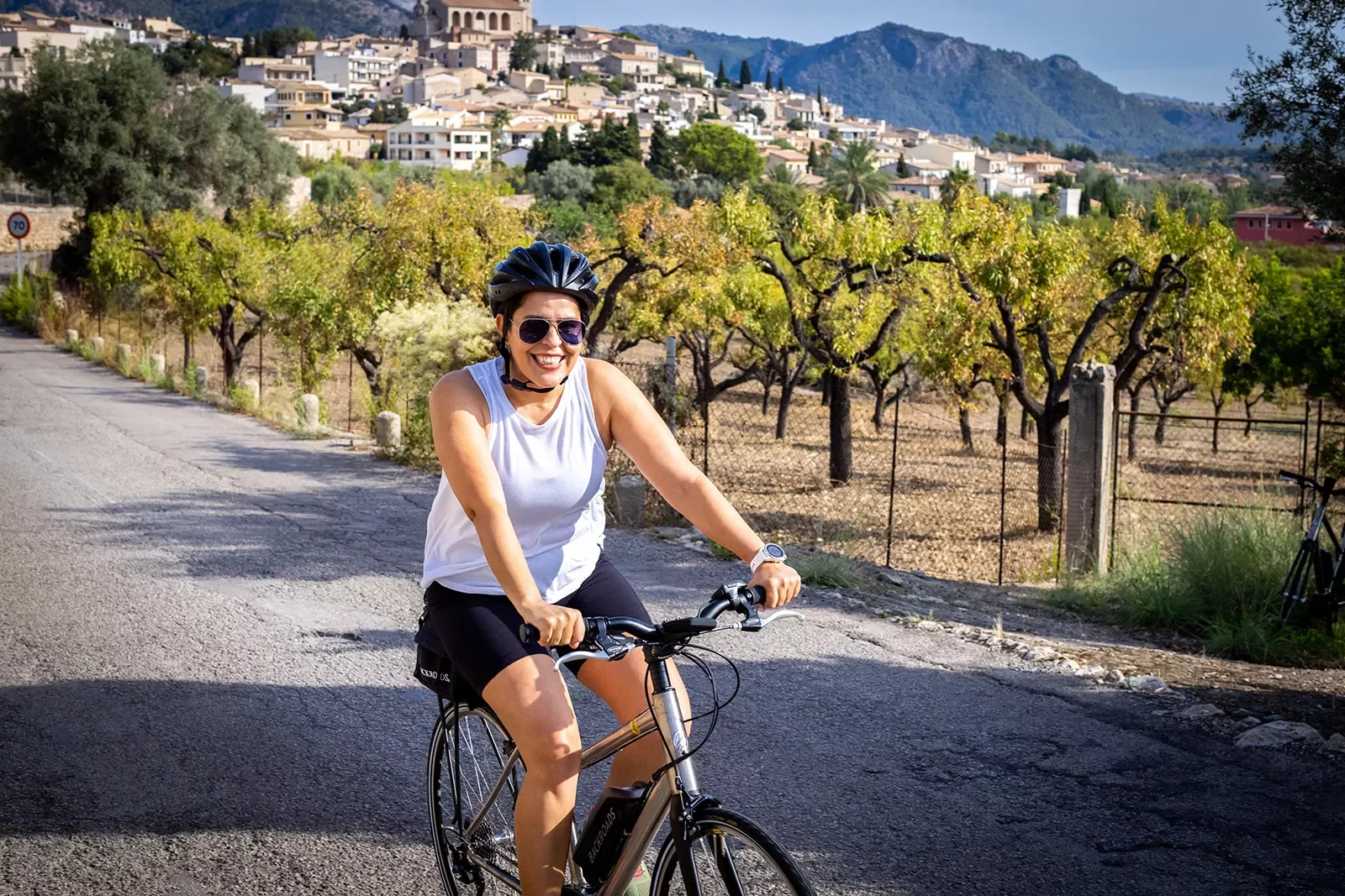 Biker riding past vineyards.