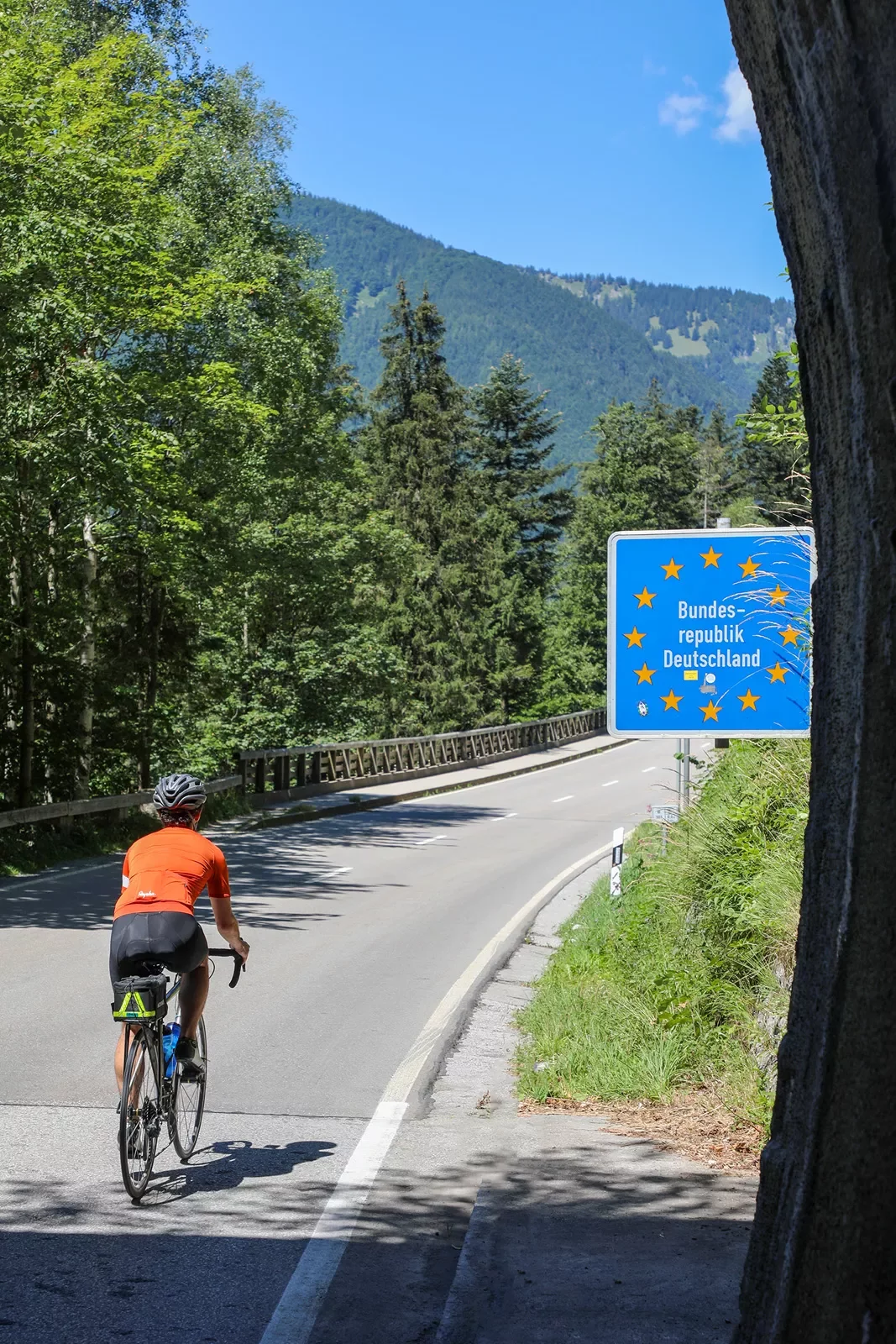 Biker riding past sign that reads &quot;Bundes-republik Deutschland&quot;