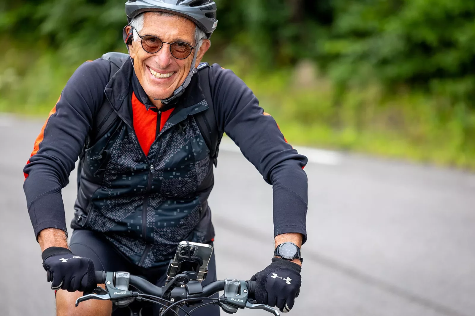 Older biker smiling while riding.