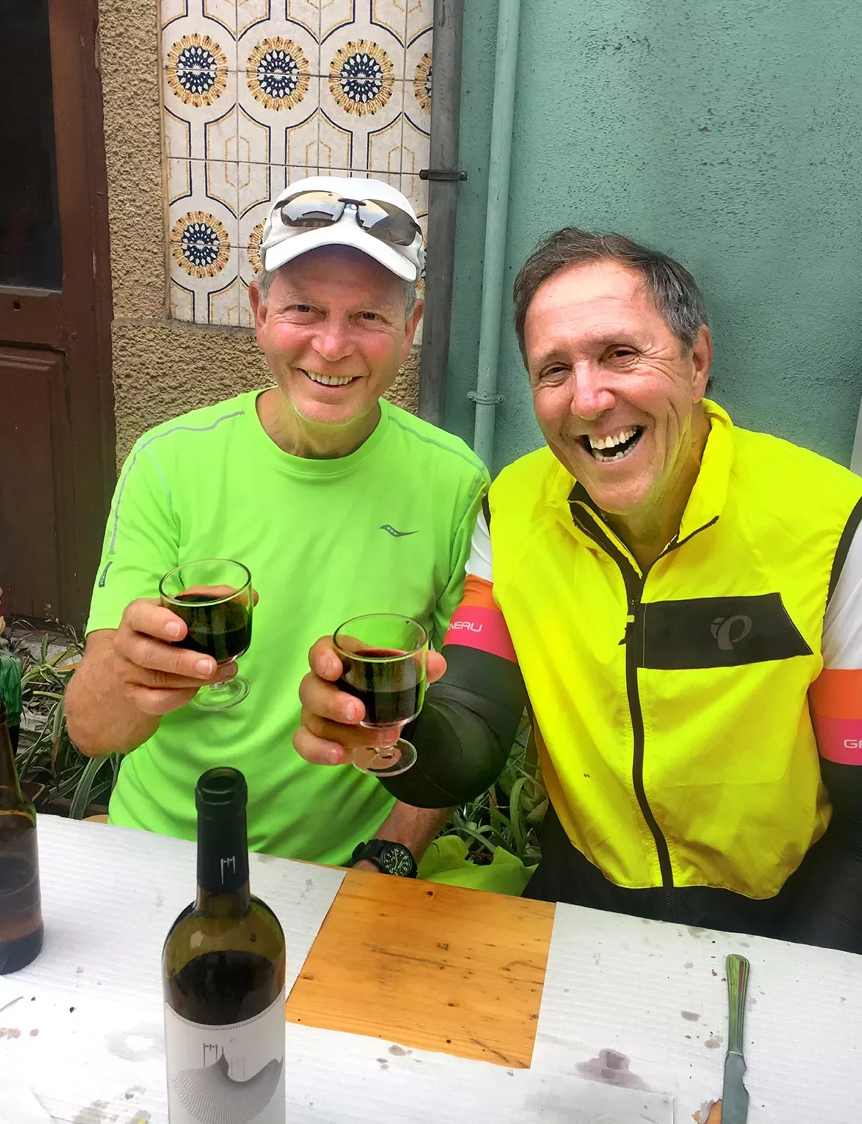 Two bikers saying cheers with glasses of red wine.