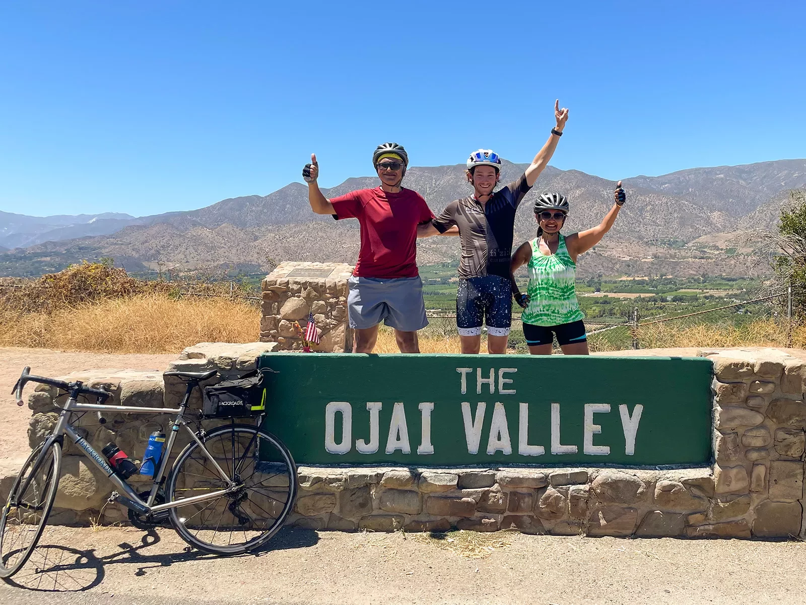 Guests behind &quot;OJAI VLLEY&quot; sign.