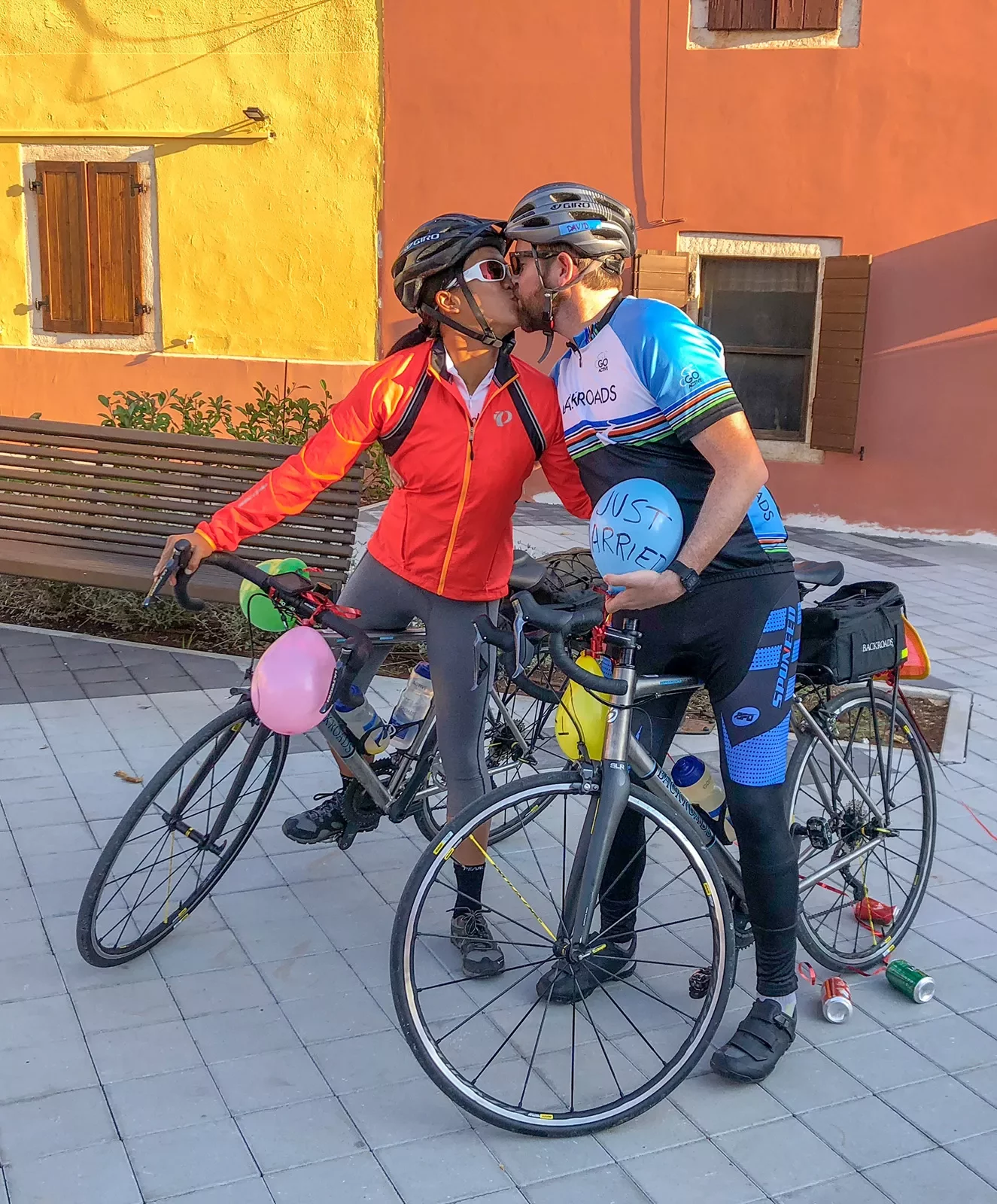 Two guests kissing while astride their bikes