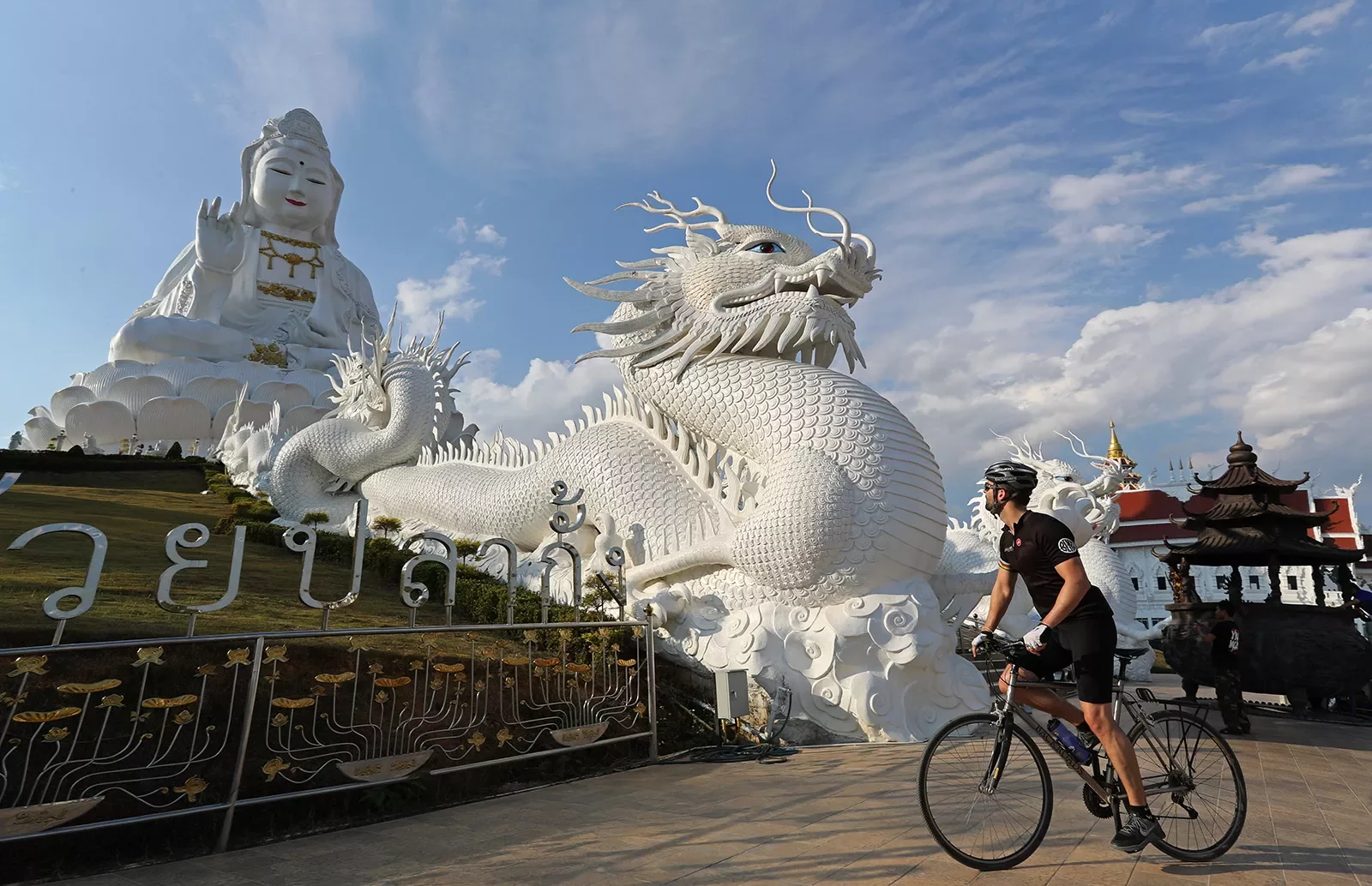 Backroads guest in front of a dragon statue in Thailand