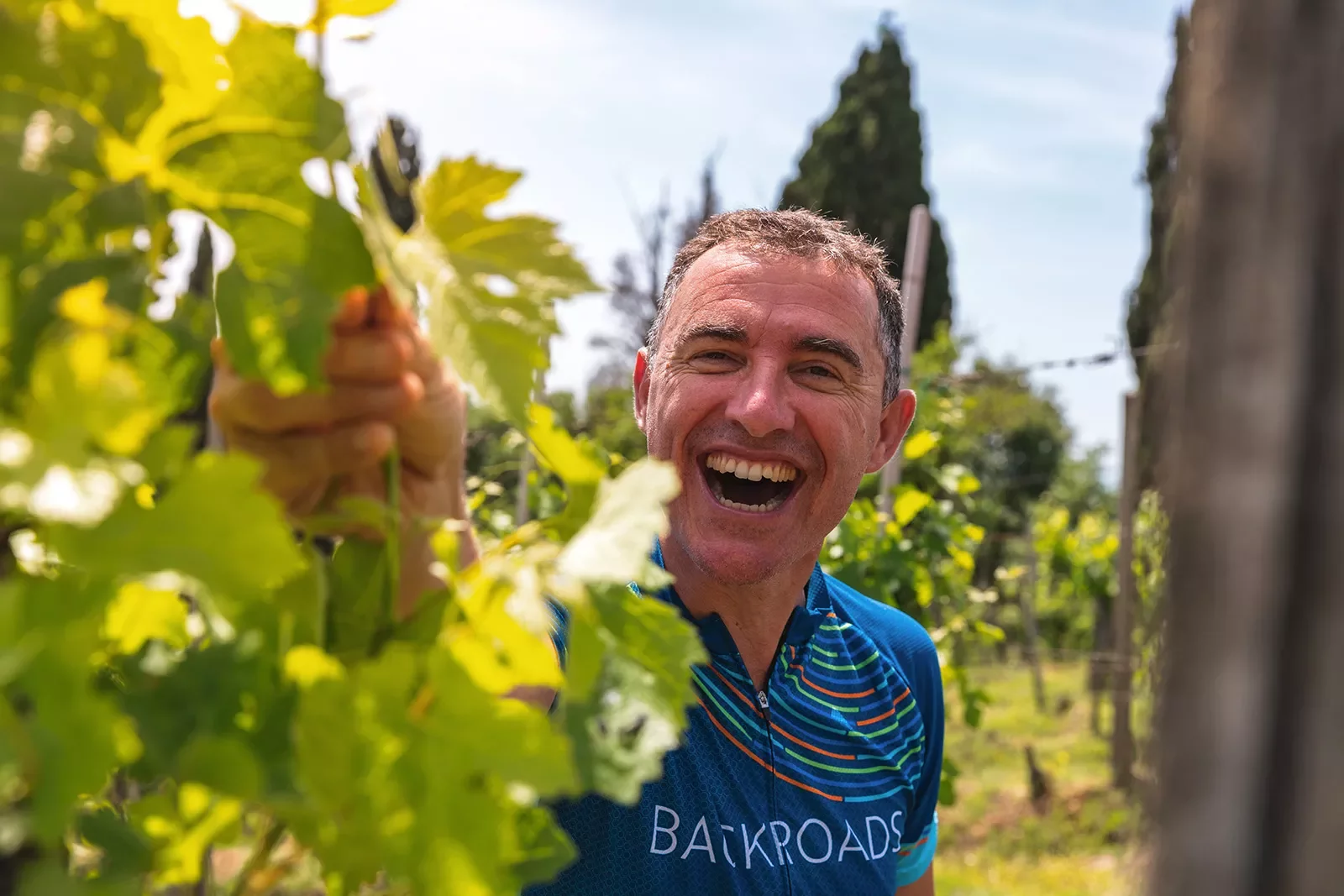 Guest laughing while inspecting grape-vine.