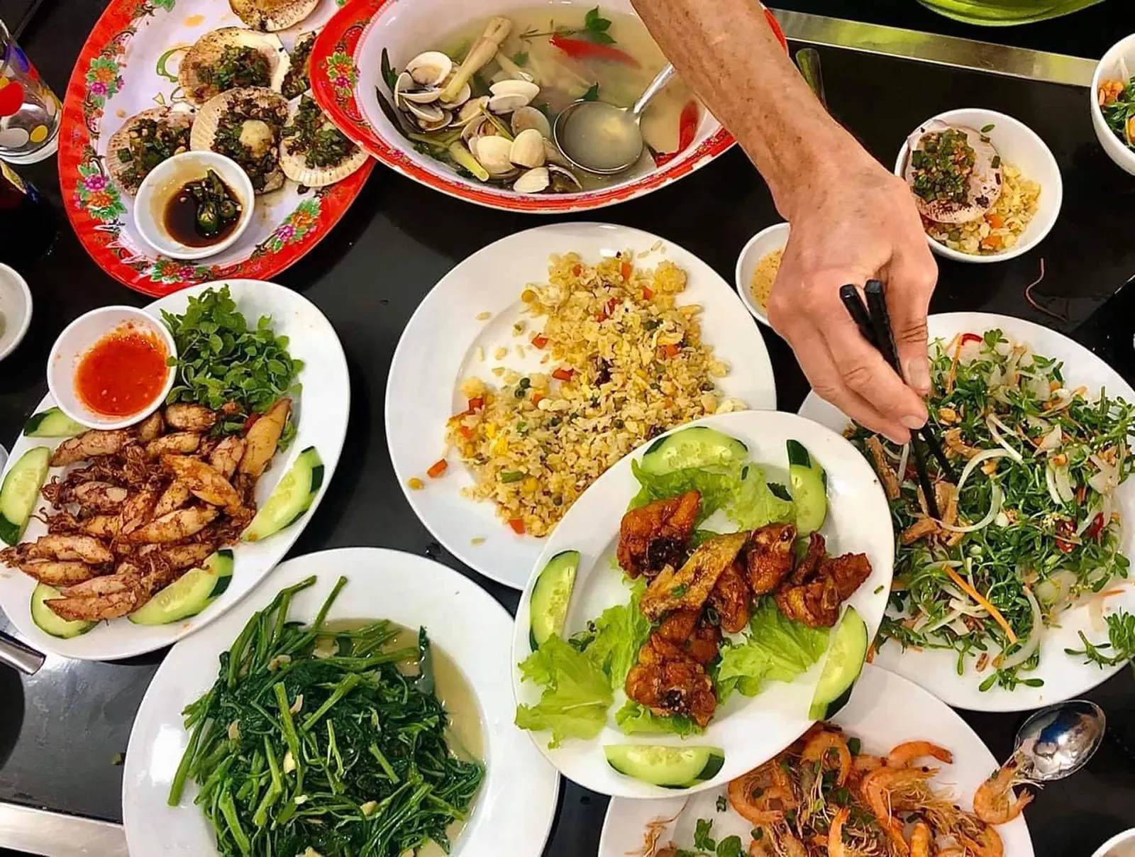 Spread of Vietnamese food, fried rice, meat, seafood, veggies, etc.