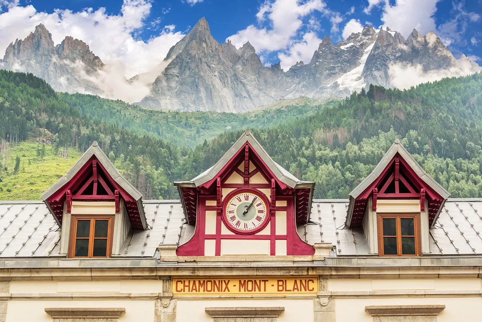 Train station clock at Chamonix Mont-Blanc, mountain in distance.