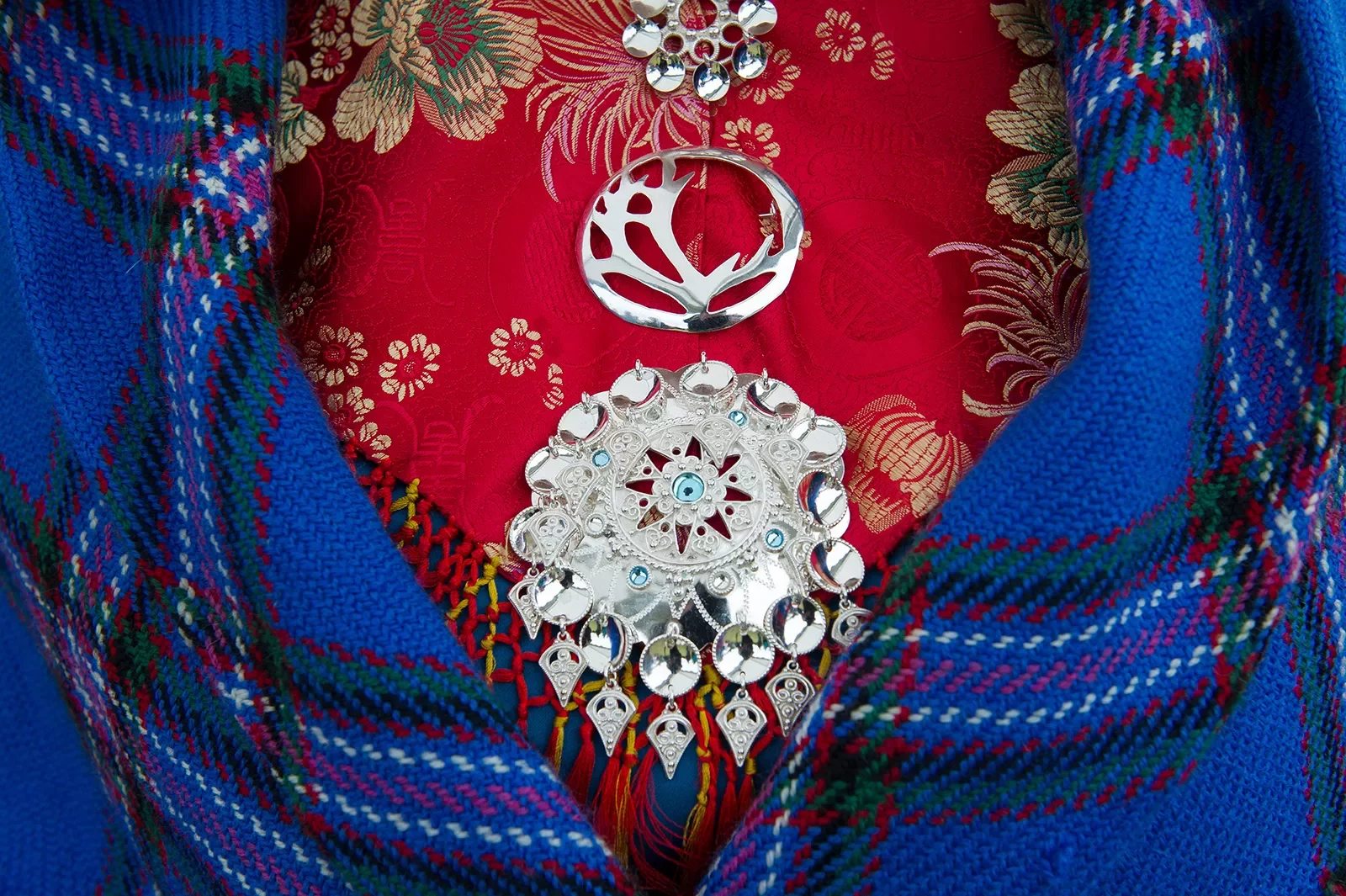 Front shot of colorful dress, medallions, blanket.