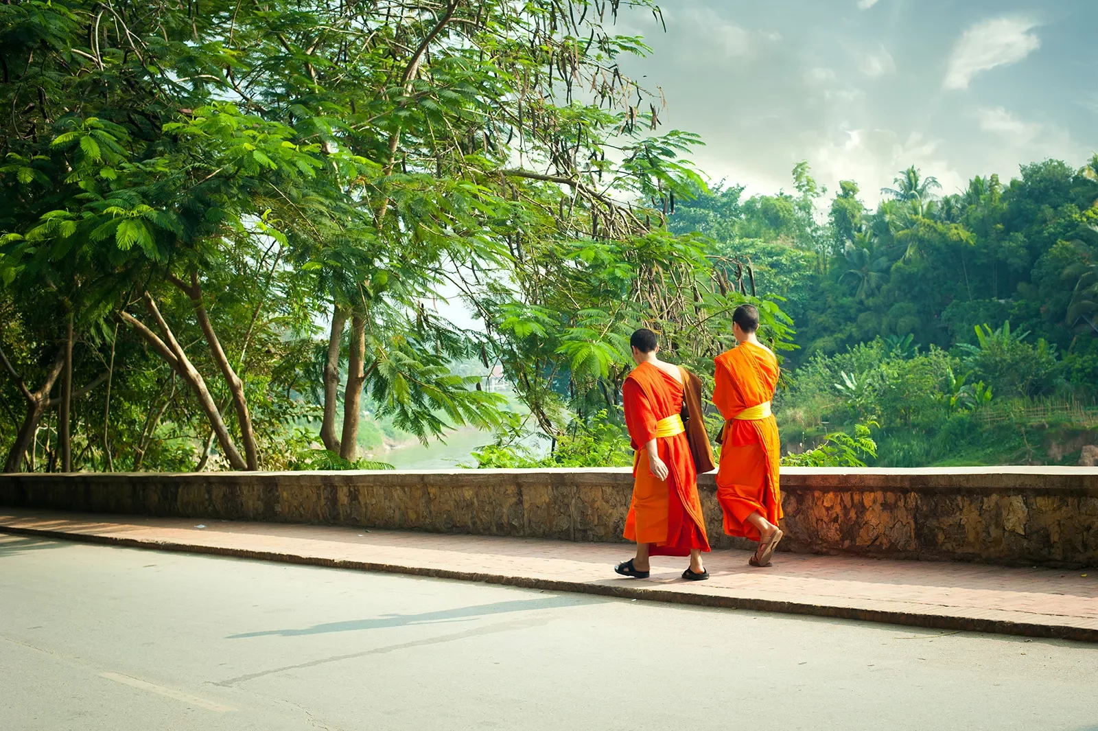 Monks walking along a road in Asia