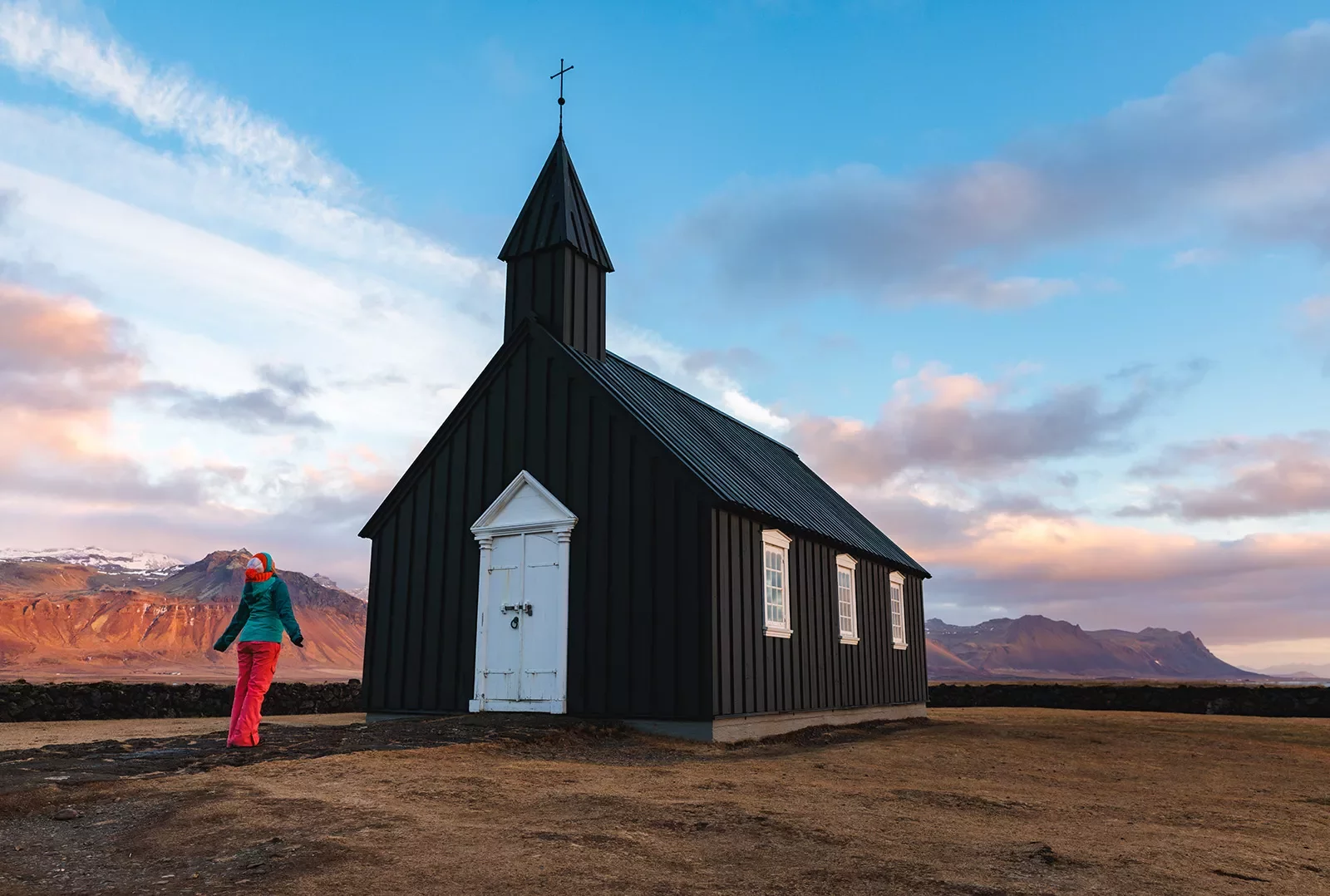 Hiker standing in front of church in Iceland.