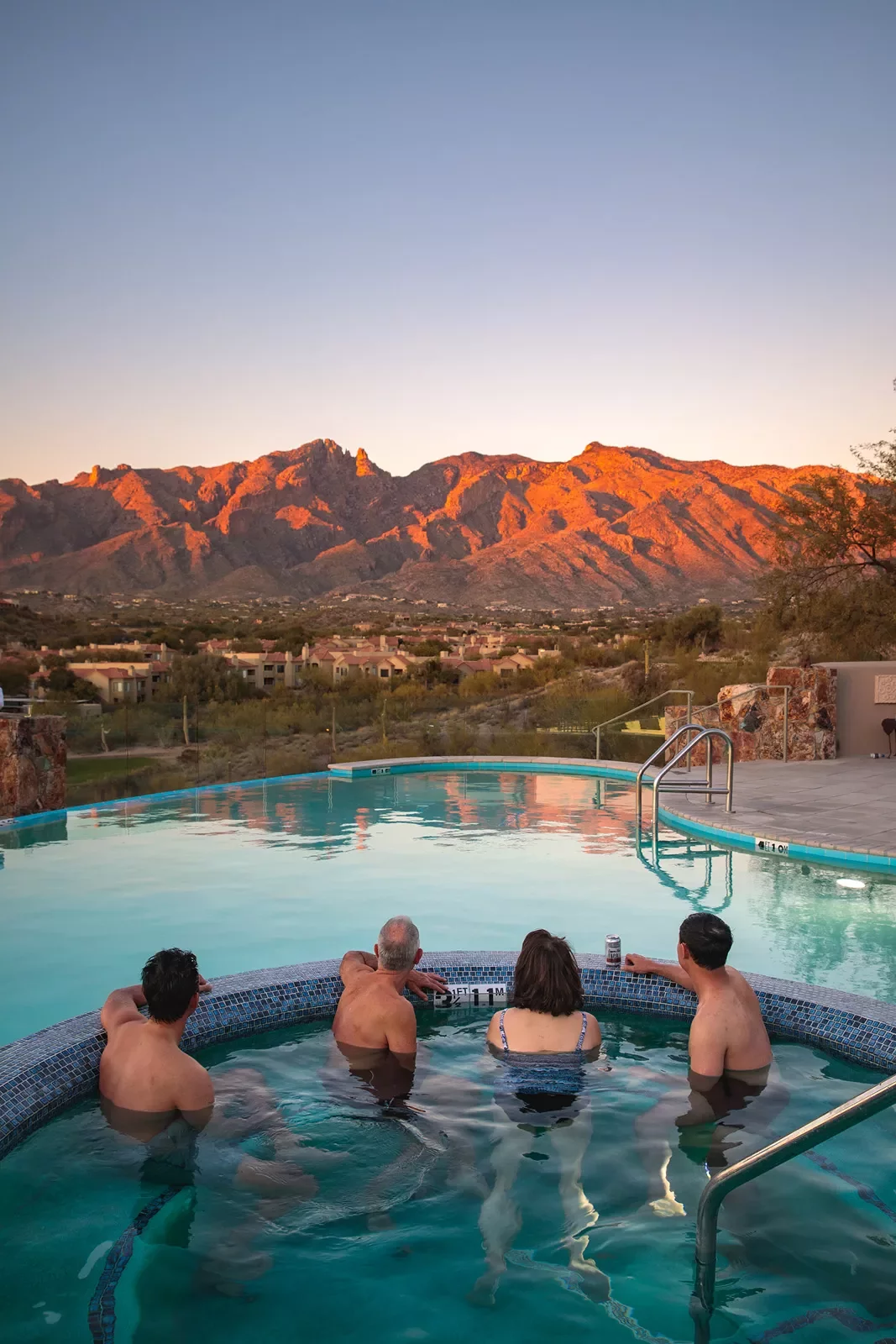 Guests in hot tub at sunset facing mountains AZ