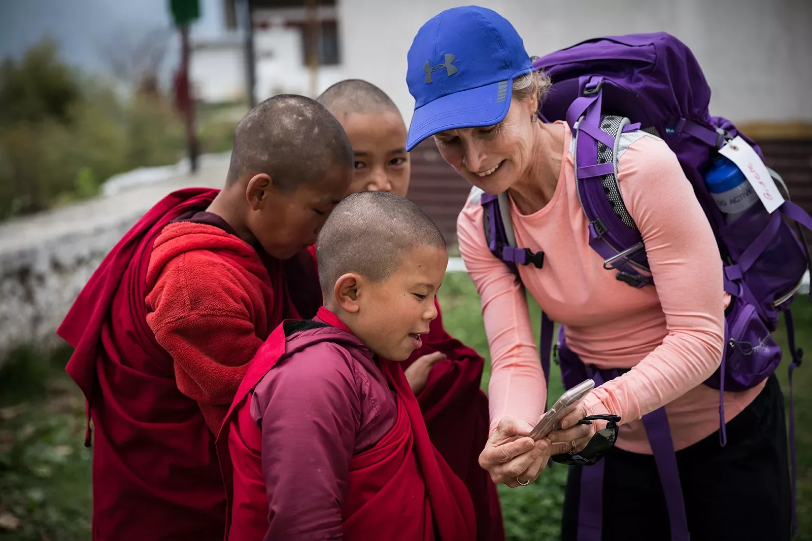 Woman showing her phone to young monks in Bhutan