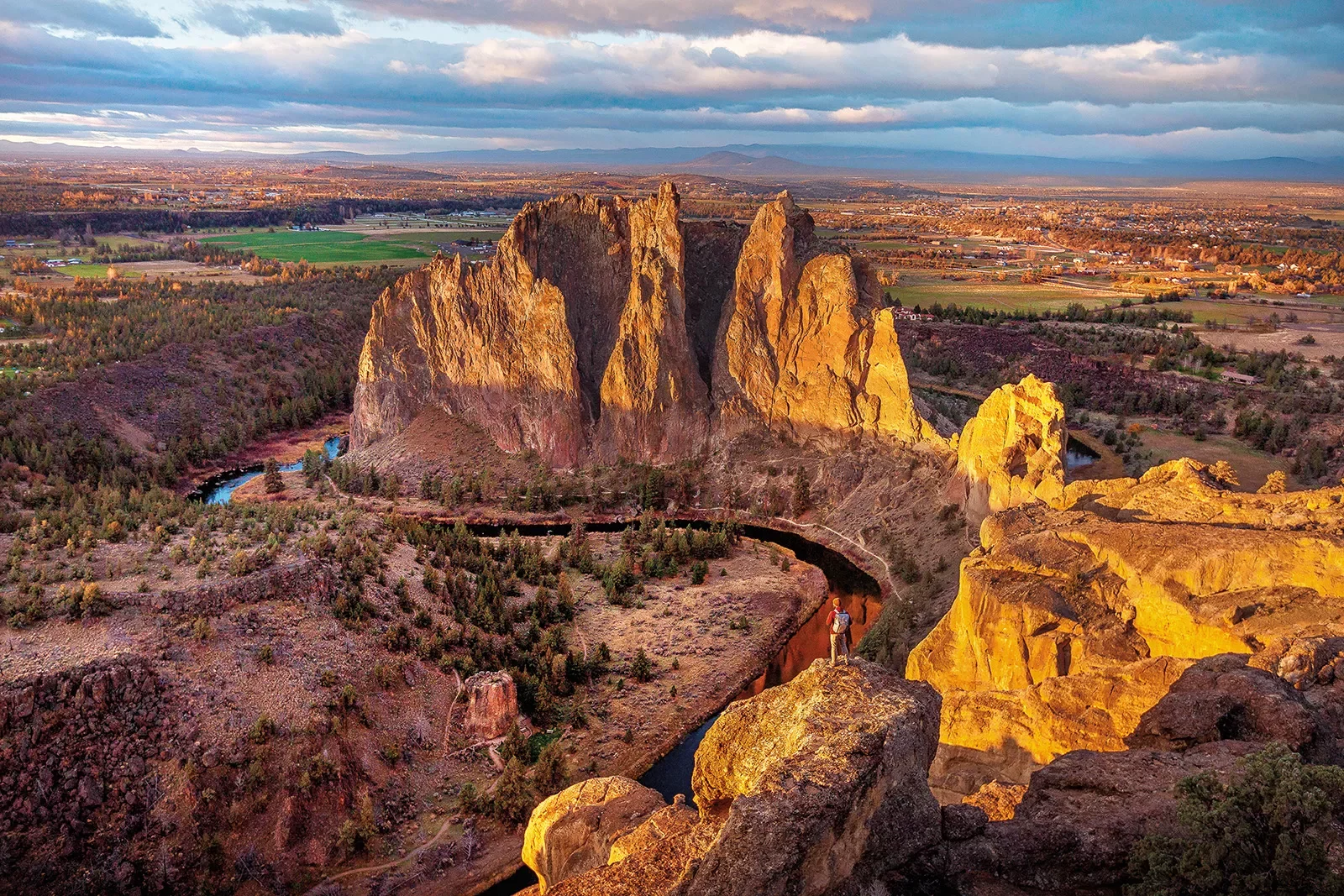 Wide shot of Smith Rock State Park, guest visible in foreground.