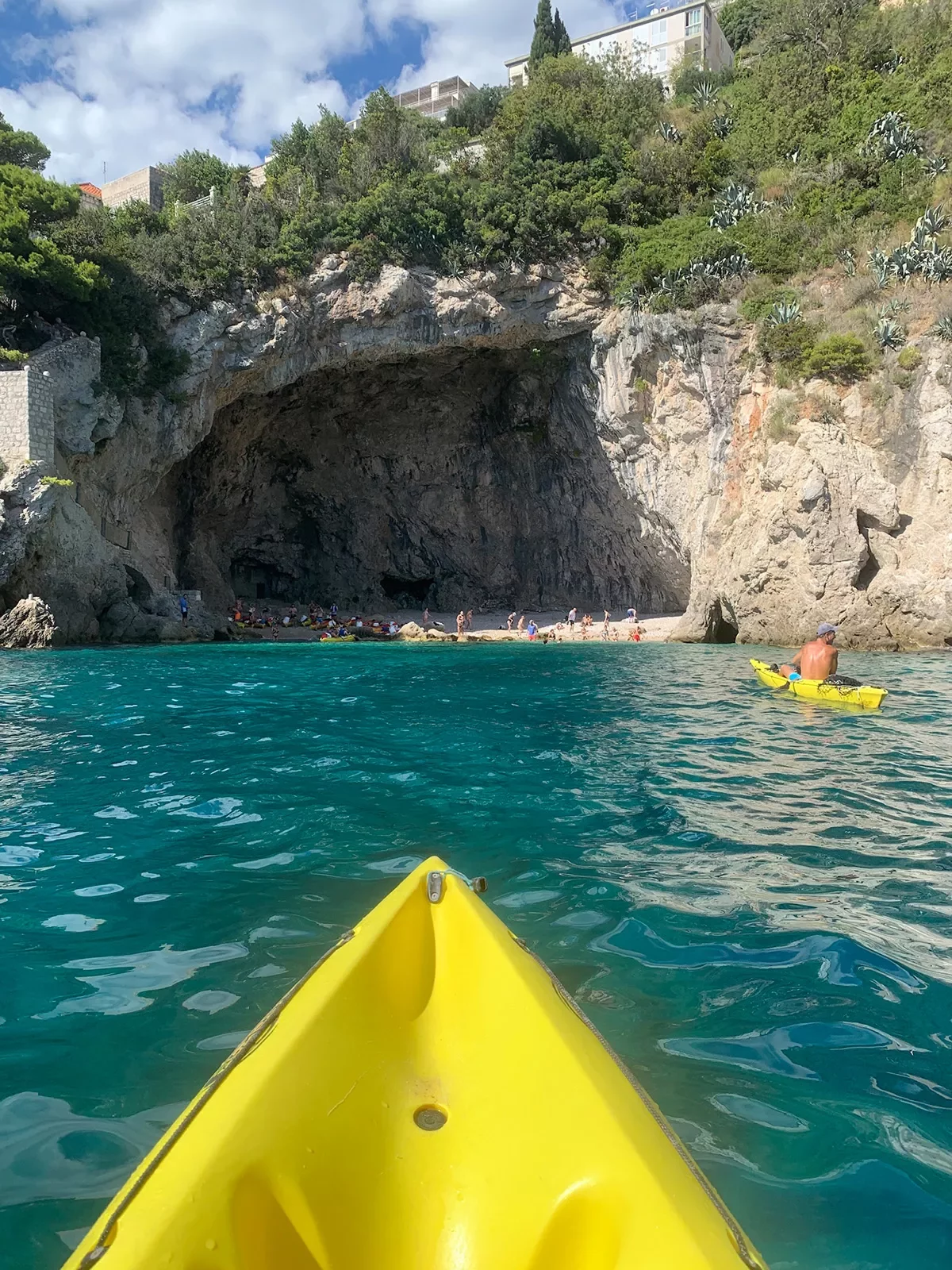 POV shot of guest kayaking, looking towards cliffside cove.
