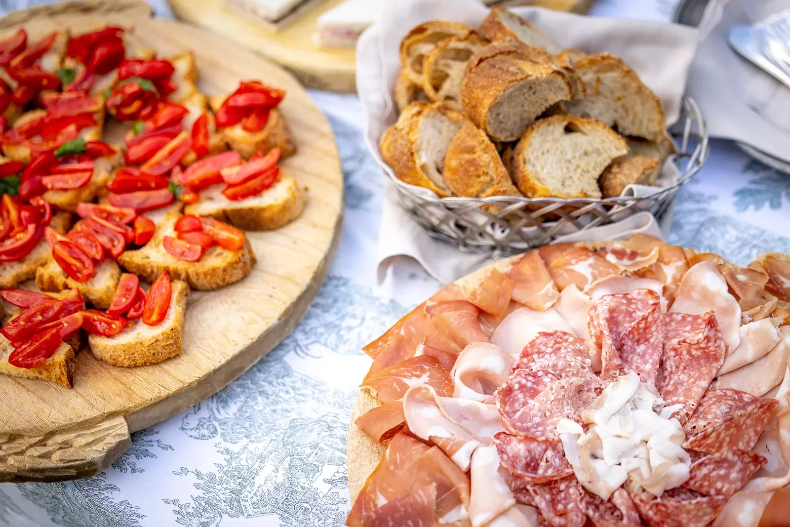 Platter of bread and tomatoes, cured meats, etc.