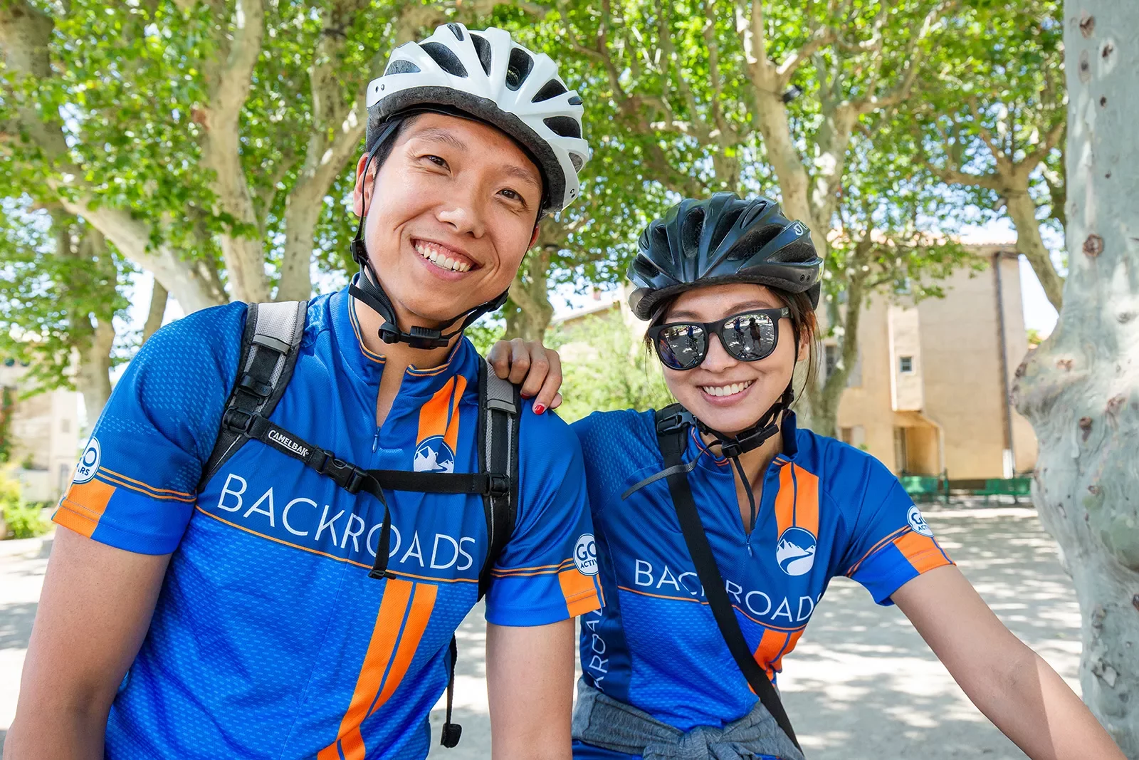 Two Backroads guests wearing bike jerseys and smiling at the camera