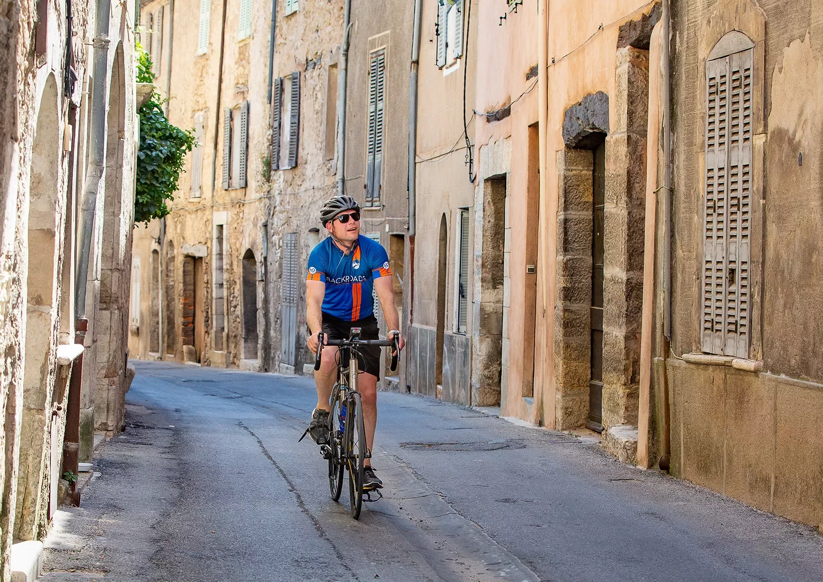 Biker riding riding through the old streets of a village in France