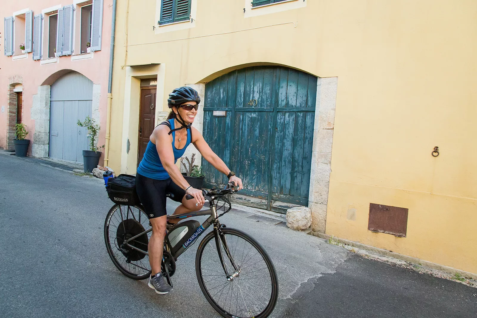 Biker riding down European alleyway.