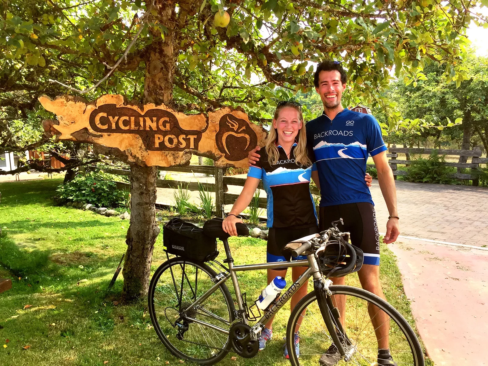 Guests posing in front of &quot;CYCLING POST&quot; sign.