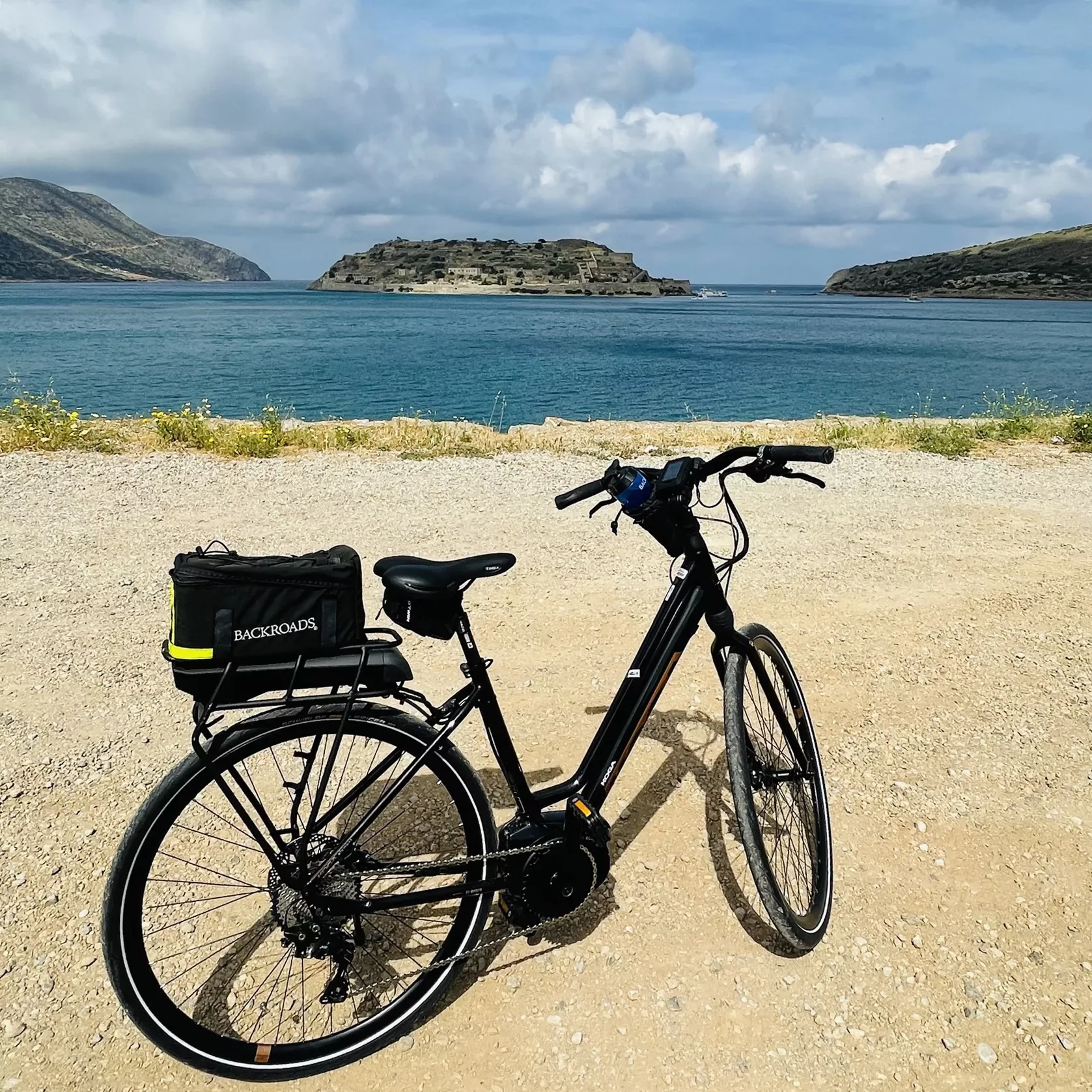 POV shot overlooking ocean, hilly islands, bike in foreground.