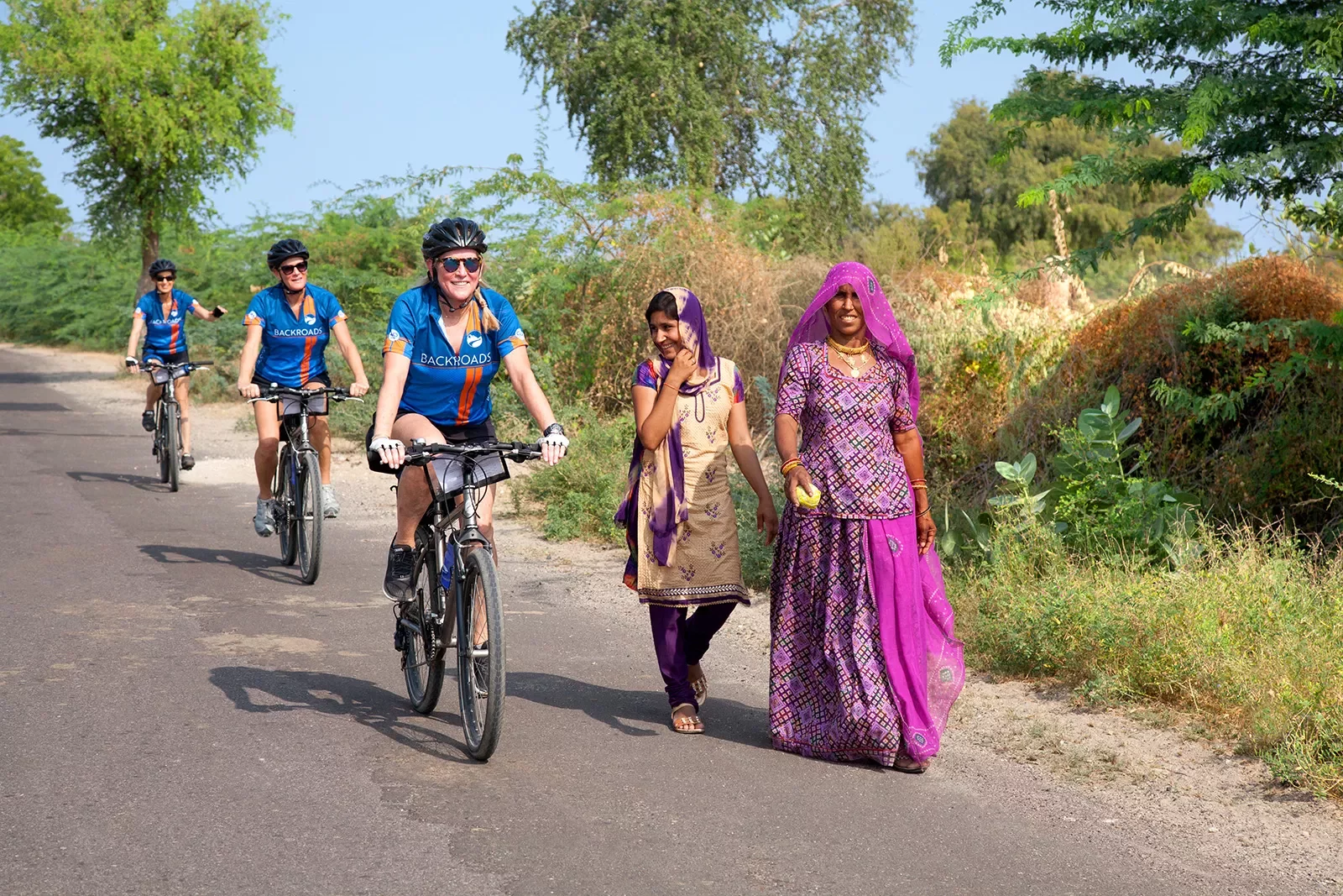 Backroads guests biking past Indian women in saris