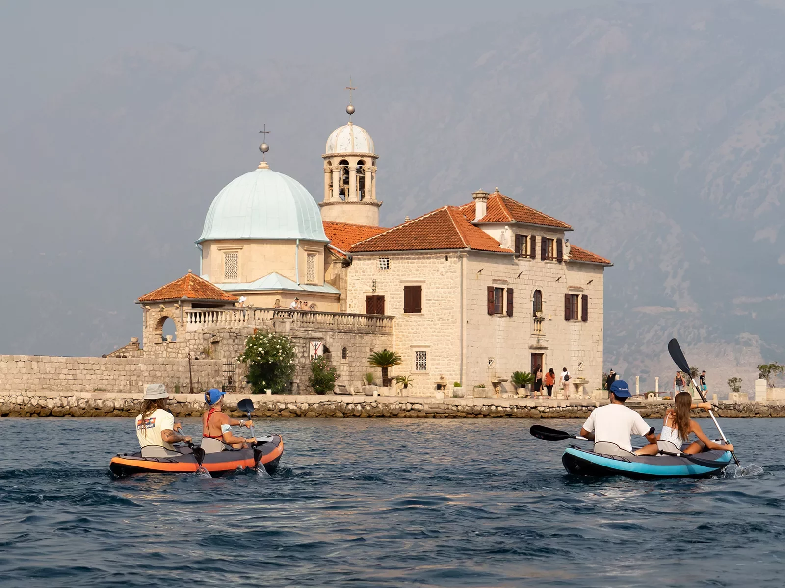 Four guests kayaking, Our Lady Of The Rocks, Montenegro in the distance.