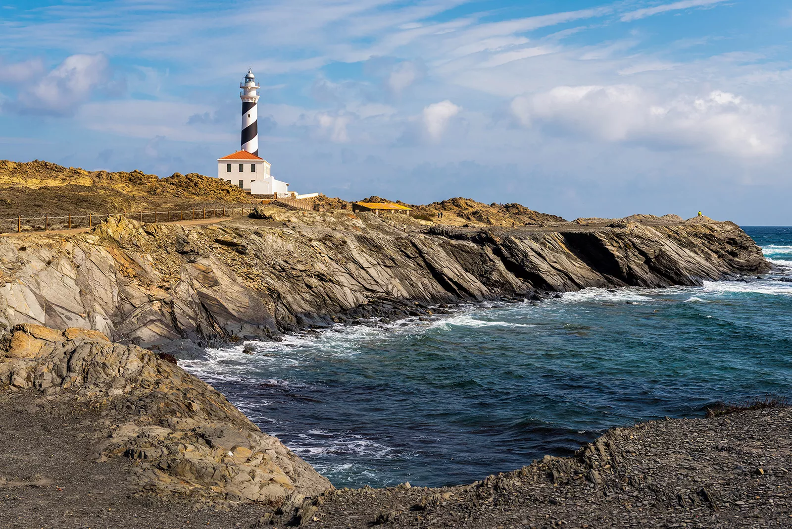 Rocky inlet, stripes lighthouse in distance.