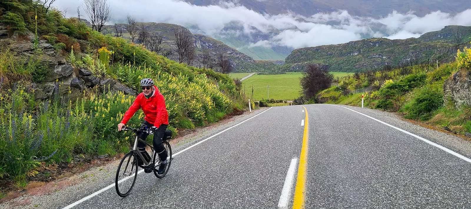 Bikers riding along a paved road in New Zealand