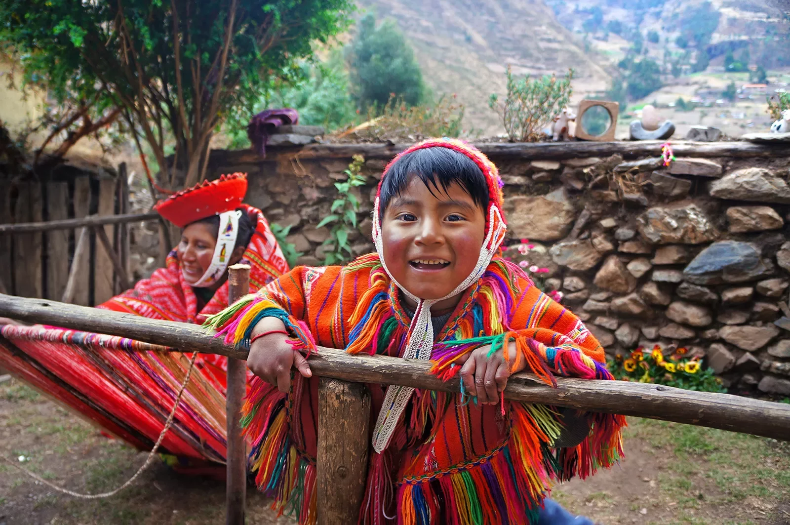 Two locals in colorful garb, one looking at camera, smiling.