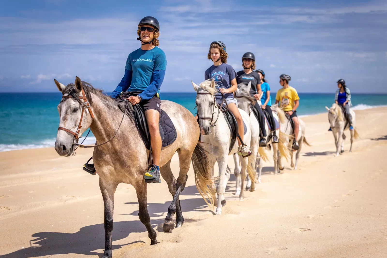 Backroads guests riding horses along the beach in Portugal