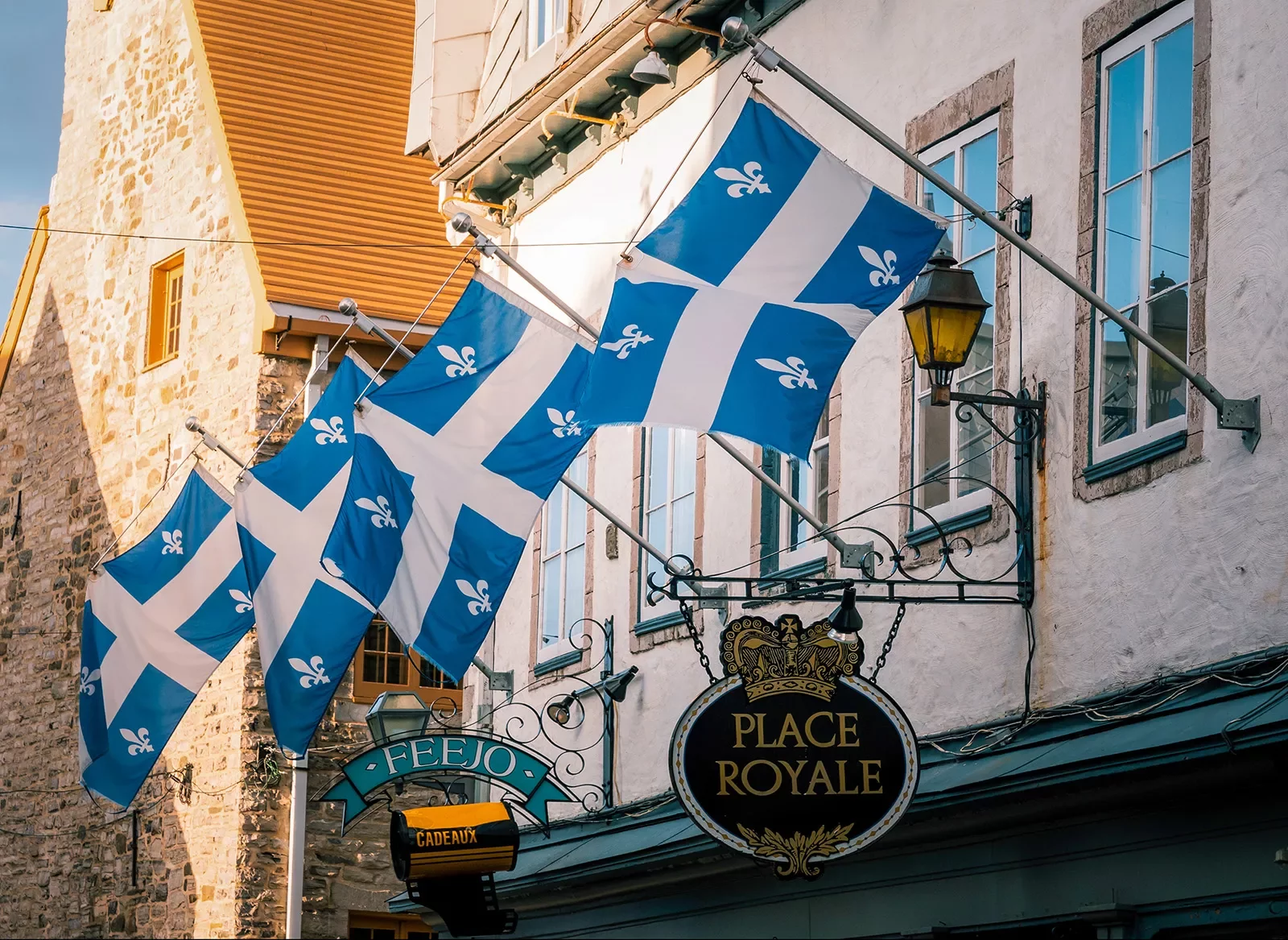 Storefront shot of &quot;PLACE ROYALE&quot;, Quebec flags proudly displayed.