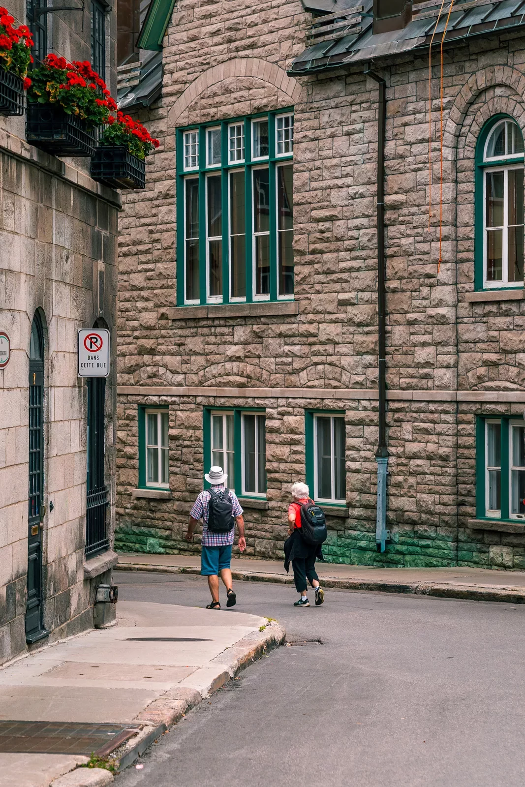 Two guests walking down brick-housed alleyway.