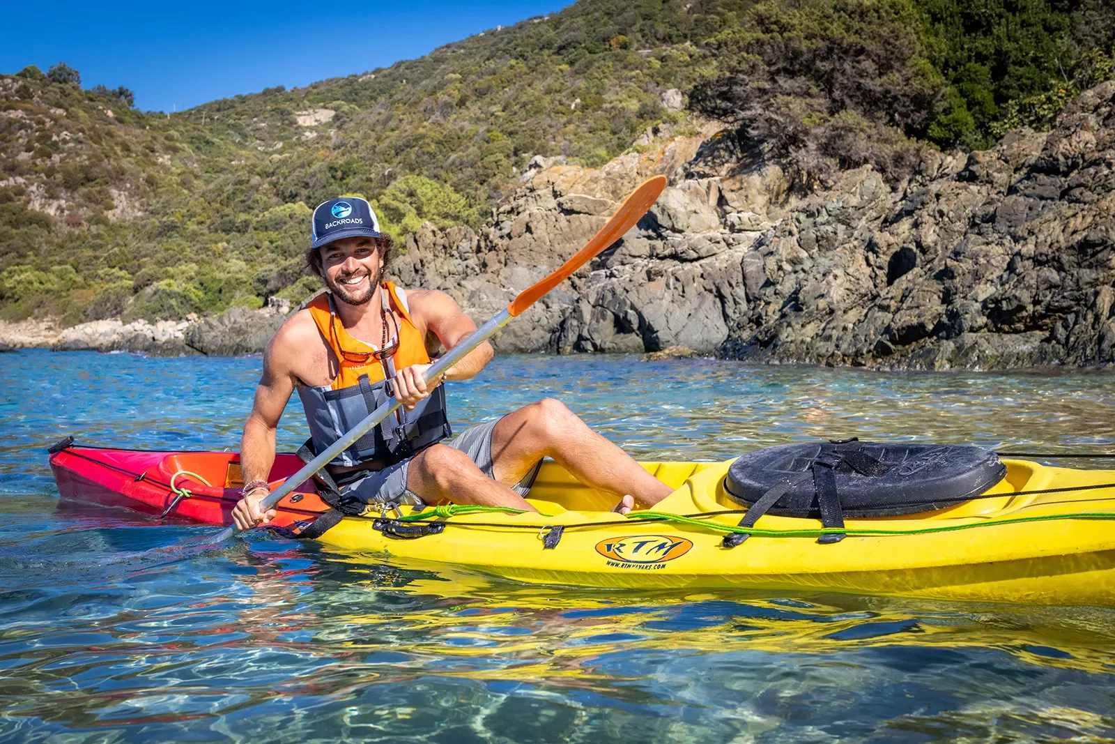 Man in a yellow kayak laughing