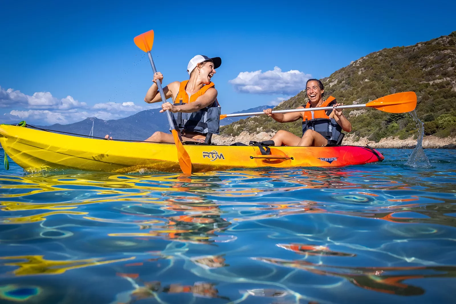 Two guests in kayak, smiling and laughing.